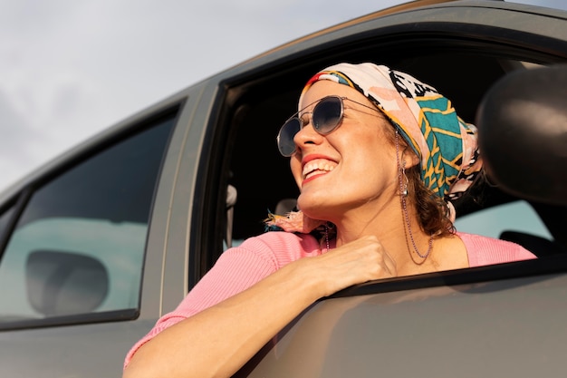 Donna sorridente che viaggia in auto