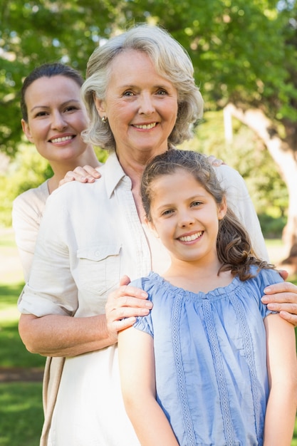 Donna sorridente con la nonna e la nipote al parco