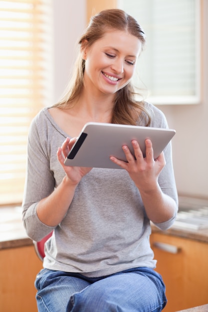 Donna sorridente con tablet in cucina