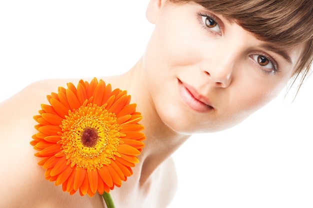 Donna sorridente con trucco creativo e fiore di gerbera su sfondo colorato