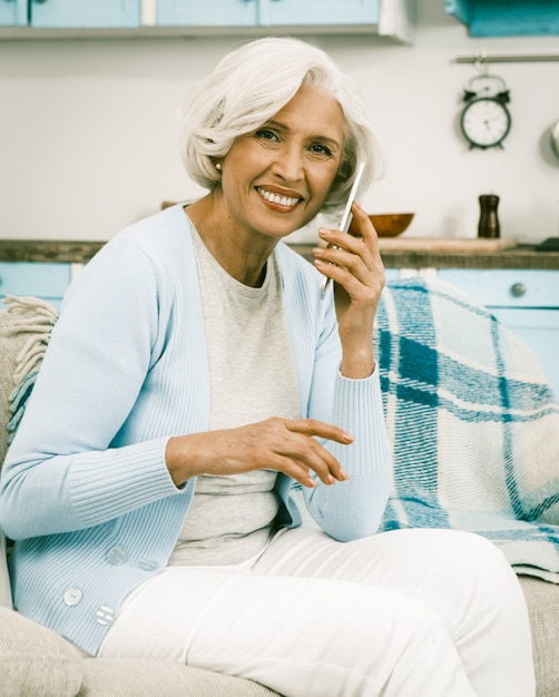 Donna sorridente dai capelli bianca italiana che fa una telefonata