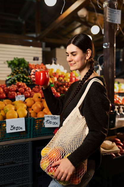 Donna sorridente del colpo medio al mercato