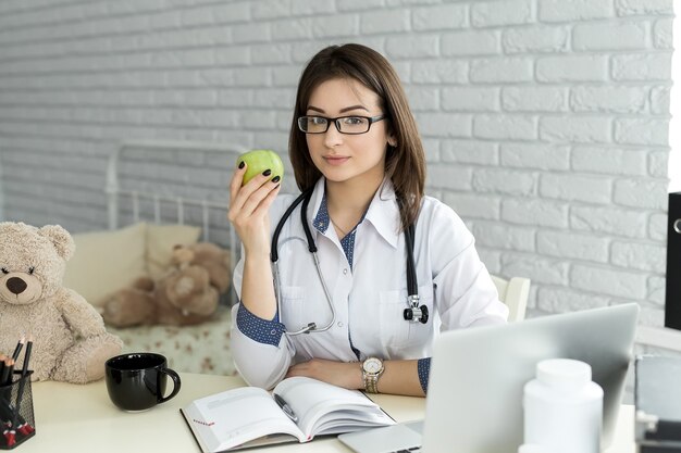 Donna sorridente del medico con la mela