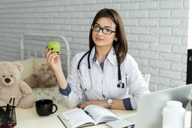 Donna sorridente del medico con la mela