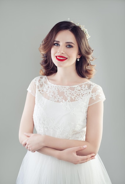 Donna sorridente della sposa nel ritratto di modo del vestito da sposa bianco