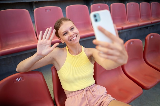 Donna sorridente di alto angolo che prende selfie