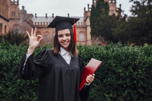 Donna sorridente di successo felice, laurea universitaria; ritratto della studentessa diploma o college con laurea