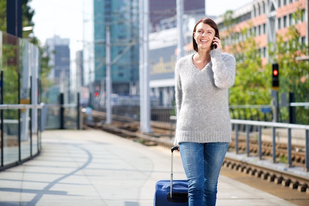 Donna sorridente di viaggio parlando sul cellulare