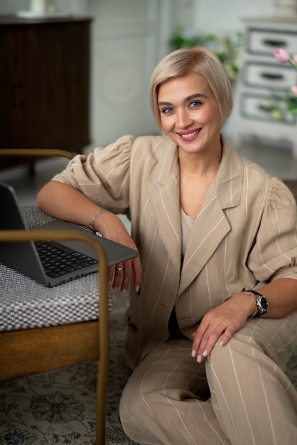 Donna sorridente di vista frontale che posa all'interno