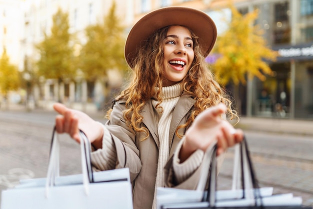 Donna sorridente dopo lo shopping sulla strada della città Acquisti concetto di vendita Concetto di shopping online