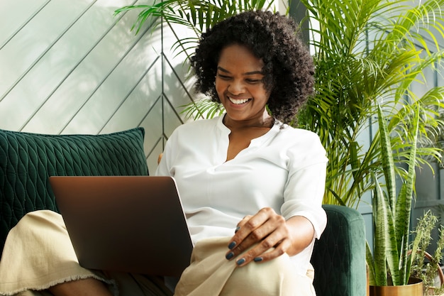 Donna sorridente durante la teleconferenza sul laptop che lavora da casa nella nuova normalità