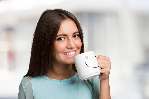 Donna sorridente e allegra che tiene una tazza sorridente