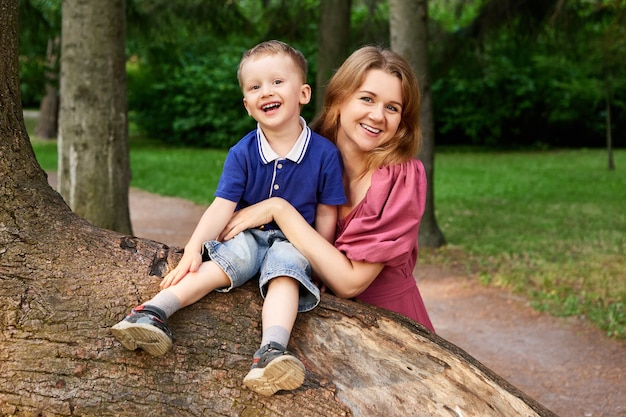 Donna sorridente e bambino camminano all'aperto