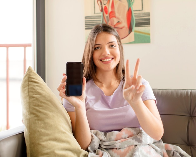 donna sorridente e donna che sembra felice, spensierata e positiva, che indica vittoria o pace con una mano