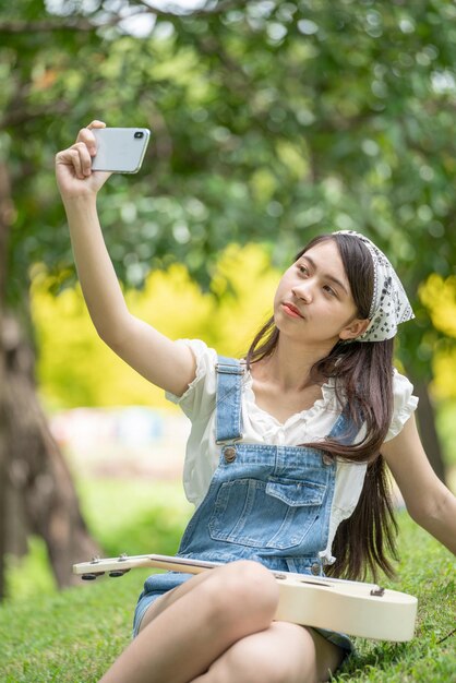 Donna sorridente e premurosa nel parco che utilizza lo smartphone per la foto selfie Ritratto di un giovane affascinante