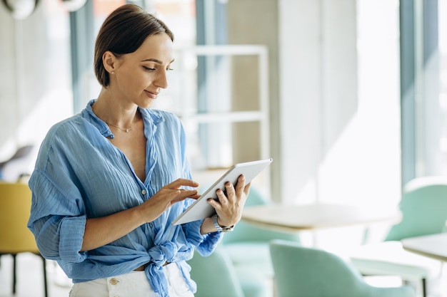 Donna sorridente e utilizzando tablet in ufficio