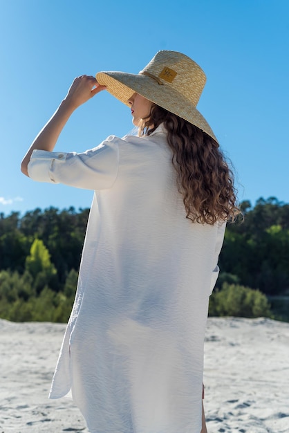 donna sorridente esile piuttosto attraente sulla spiaggia soleggiata in abito di tendenza moda stile estivo felice, libero