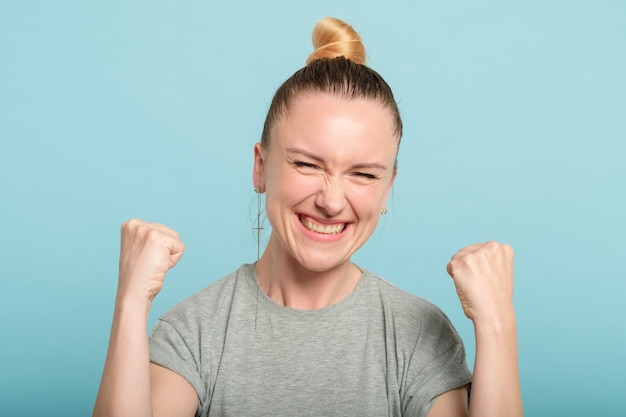 Donna sorridente felice che fa il gesto di sì. mani in pugno. vincere il successo e la realizzazione.