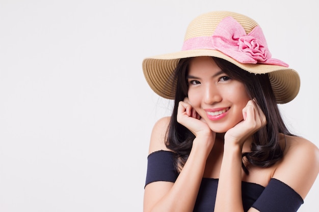 Donna sorridente felice che indossa il cappello da viaggio estivo. ritratto di viaggiatore donna ottimista positivo, studio bianco isolato con vacanza o concetto di vacanza. giovane adulto bella ragazza donna asiatica modello