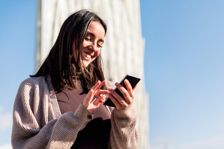 Donna sorridente felice mentre si utilizza il suo telefono cellulare