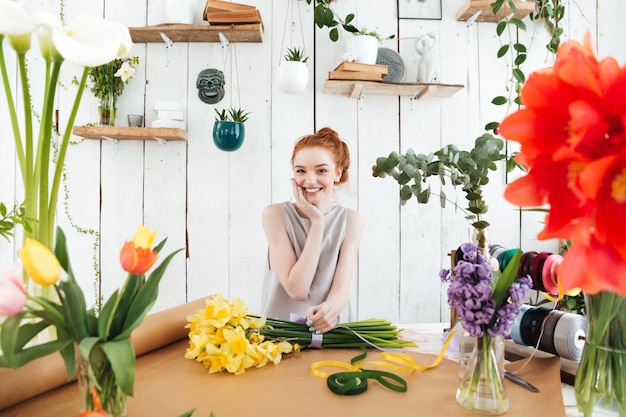 Donna sorridente mentre si lavora con i fiori