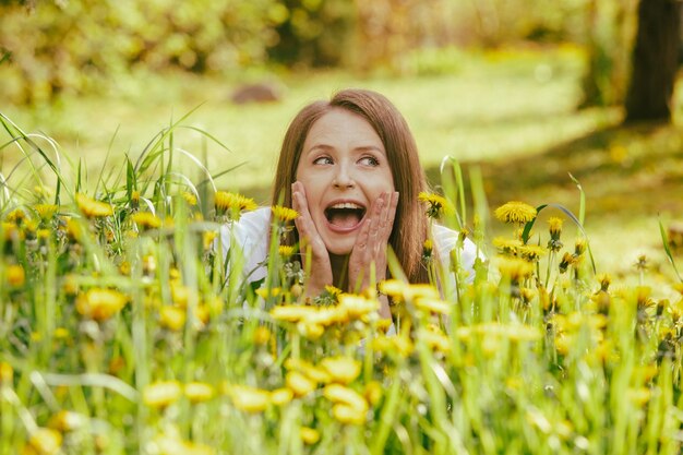 Donna sorridente sdraiata al campo di tarassaco