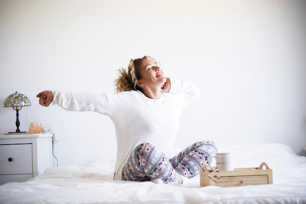 Donna sorridente seduta sul letto