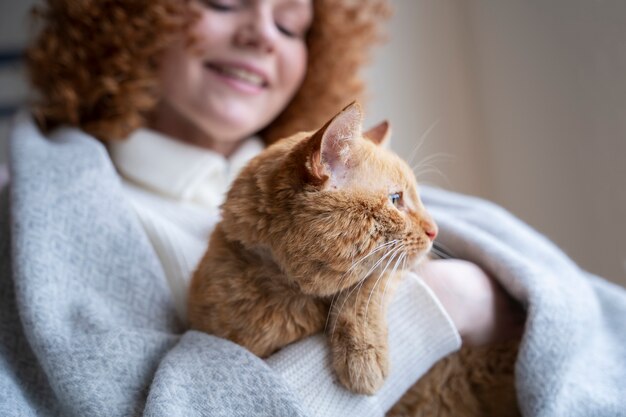 Donna sorridente sfocata che tiene gatto