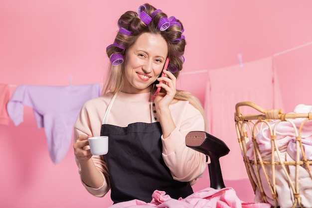 Donna sorridente soddisfatta che parla al telefono con la persona amata con felicità buone notizie durante la pulizia