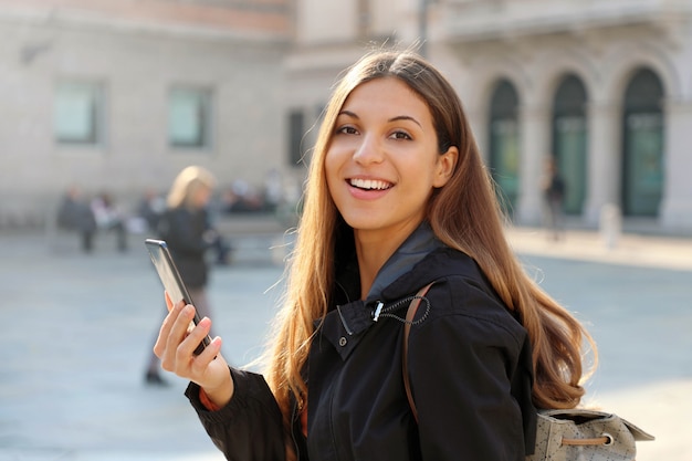 Donna sorridente usando il suo smartphone