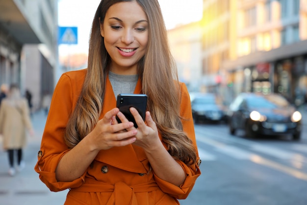 Donna sorridente utilizzando uno smartphone