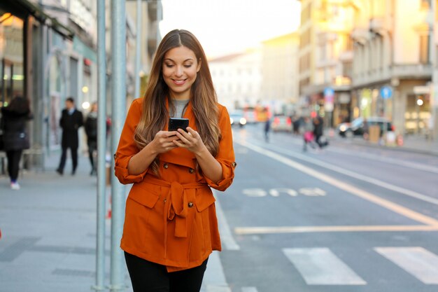 Donna sorridente utilizzando uno smartphone