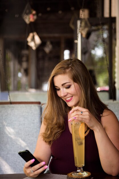 Donna sovrappeso seduto in un bar e bere limonata. Modello XXL.