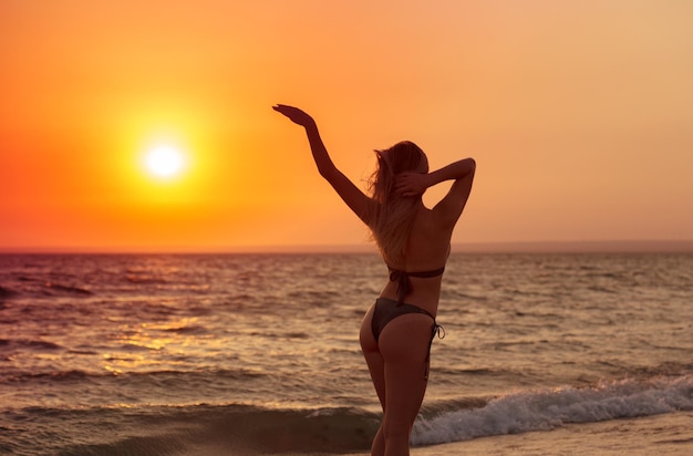 Donna spensierata felice sulla spiaggia che gode dell'estate