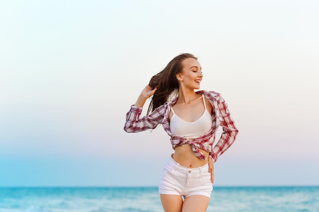 Donna spensierata felice sulla spiaggia che si gode l'estate