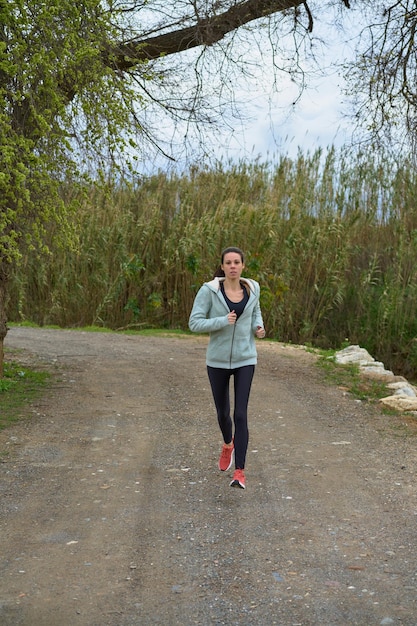 Donna sportiva che corre nella foresta