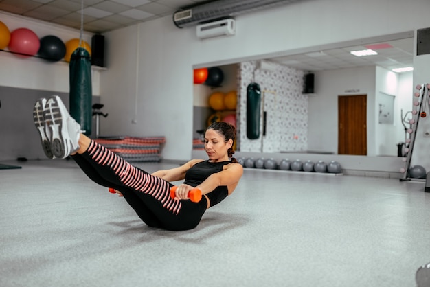 Donna sportiva che fa esercizio di fitness potenza in palestra