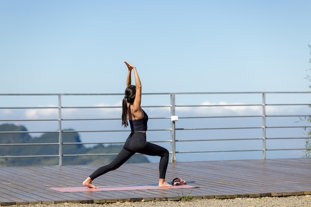 Donna sportiva fa yoga con la montagna