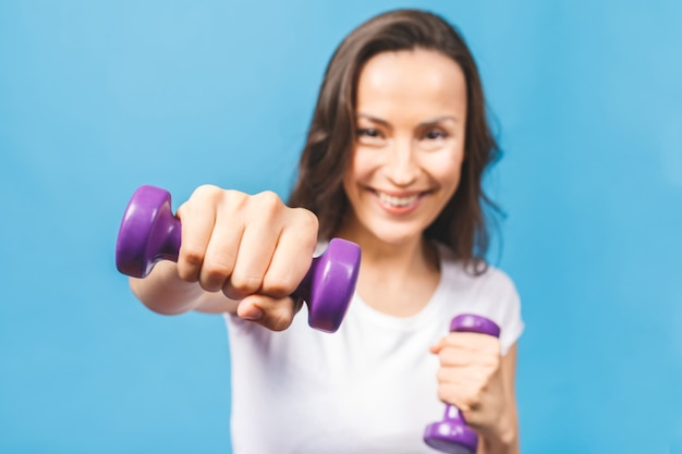 Donna sportiva facendo esercizi di boxe facendo colpo diretto con manubri