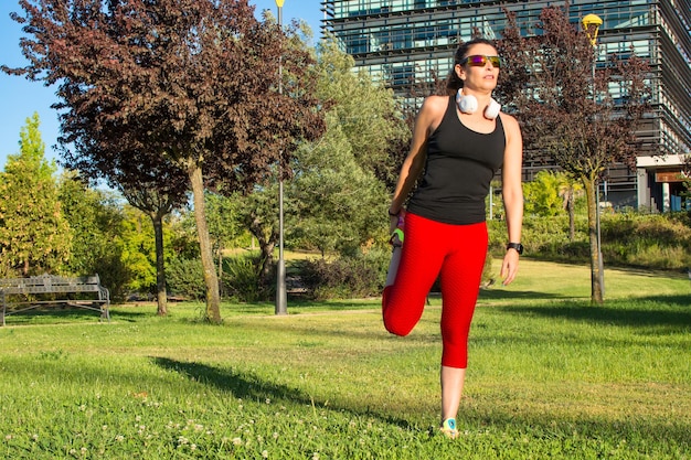 Donna sportiva facendo esercizi di stretching muscolare nel parco. Uno stile di vita sano. Esercizi di stretching