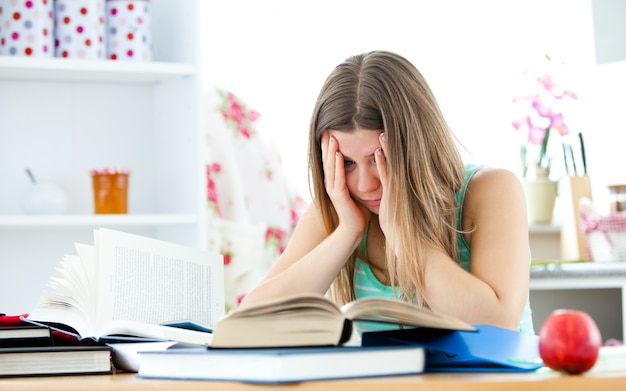 Donna stanca che studia in cucina