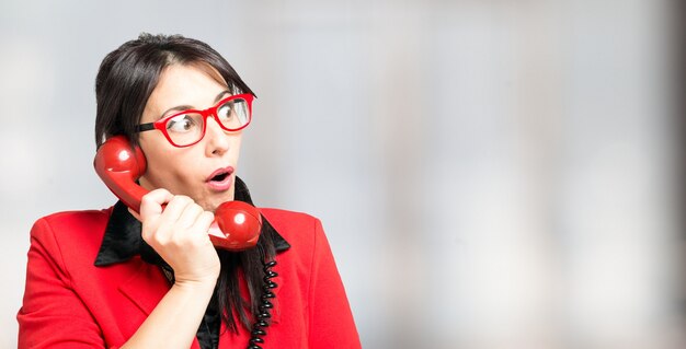 Donna stupita utilizzando un telefono vintage. Grande copia-spazio