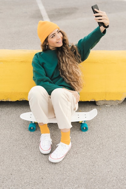 Donna su skateboard prendendo selfie