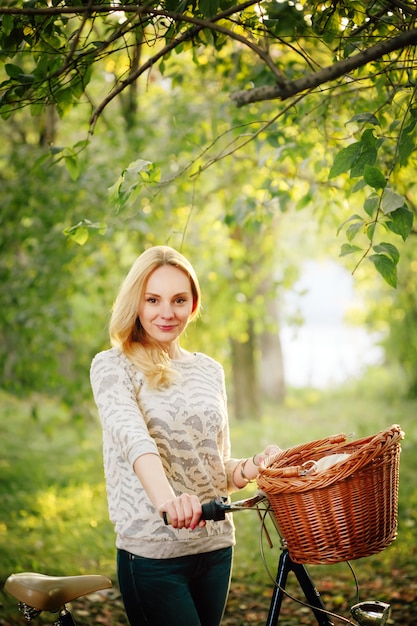 Donna su una bicicletta d'epoca in campagna