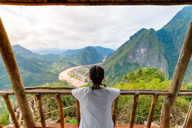 Donna sul balcone in legno conquistare la cima della montagna a Nong Khiaw Nam Ou River Valley Laos