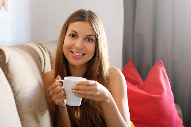 Donna sul divano con in mano una tazza di caffè