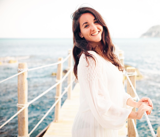 donna sul ponte vicino al mare