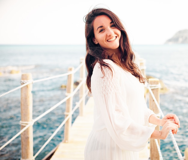 donna sul ponte vicino al mare