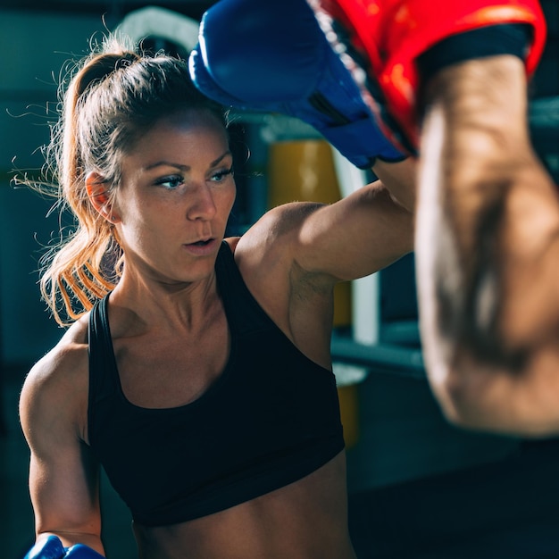 Donna sull'allenamento di boxe con l'istruttore