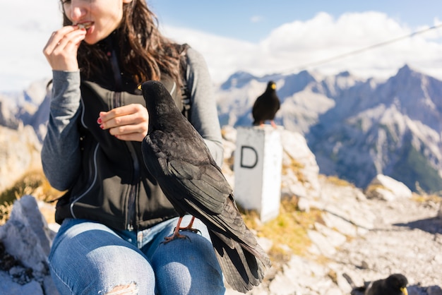 Donna sull&#39;aumento della montagna che riposa mangiando pane